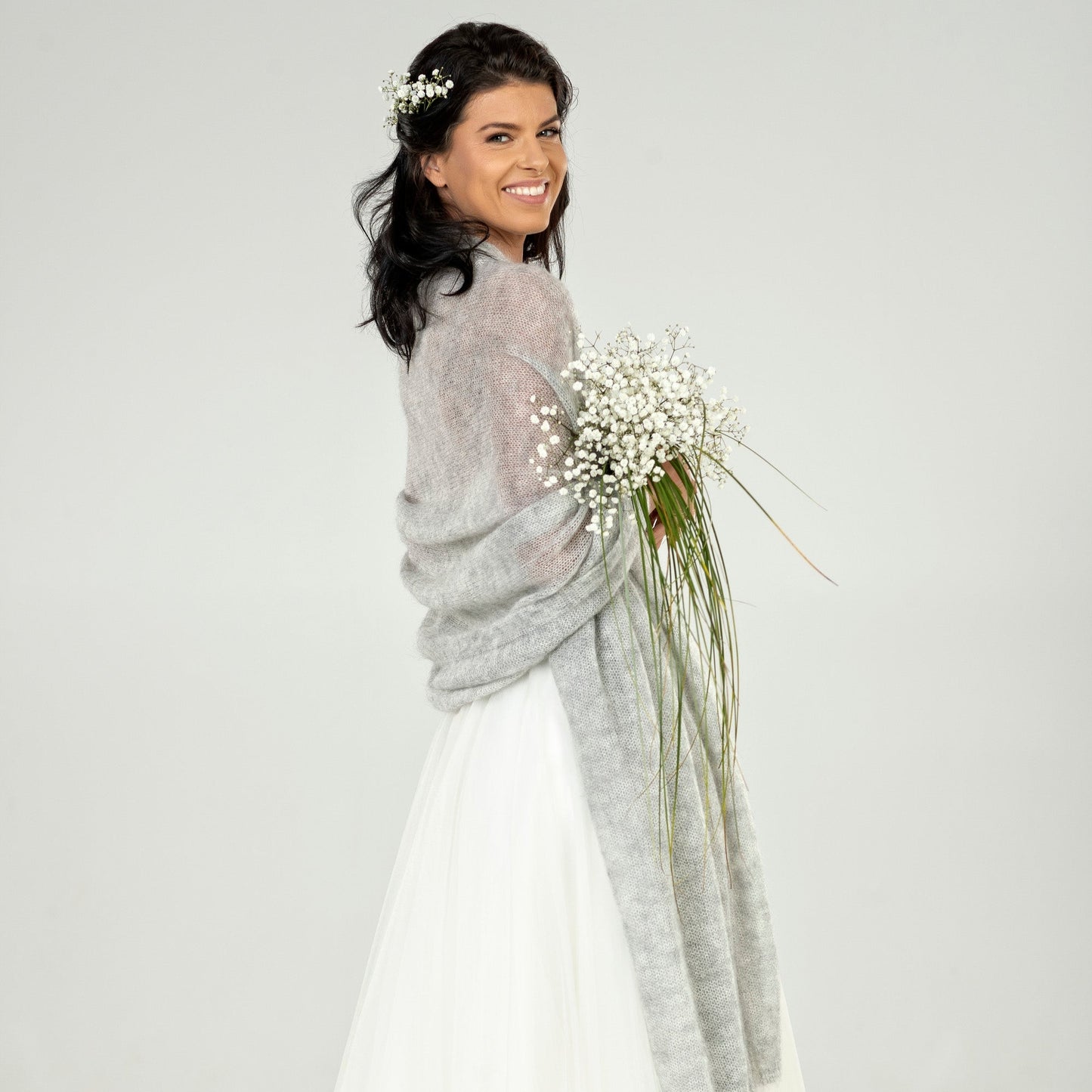 Woman in a wedding dress with a gray cape
