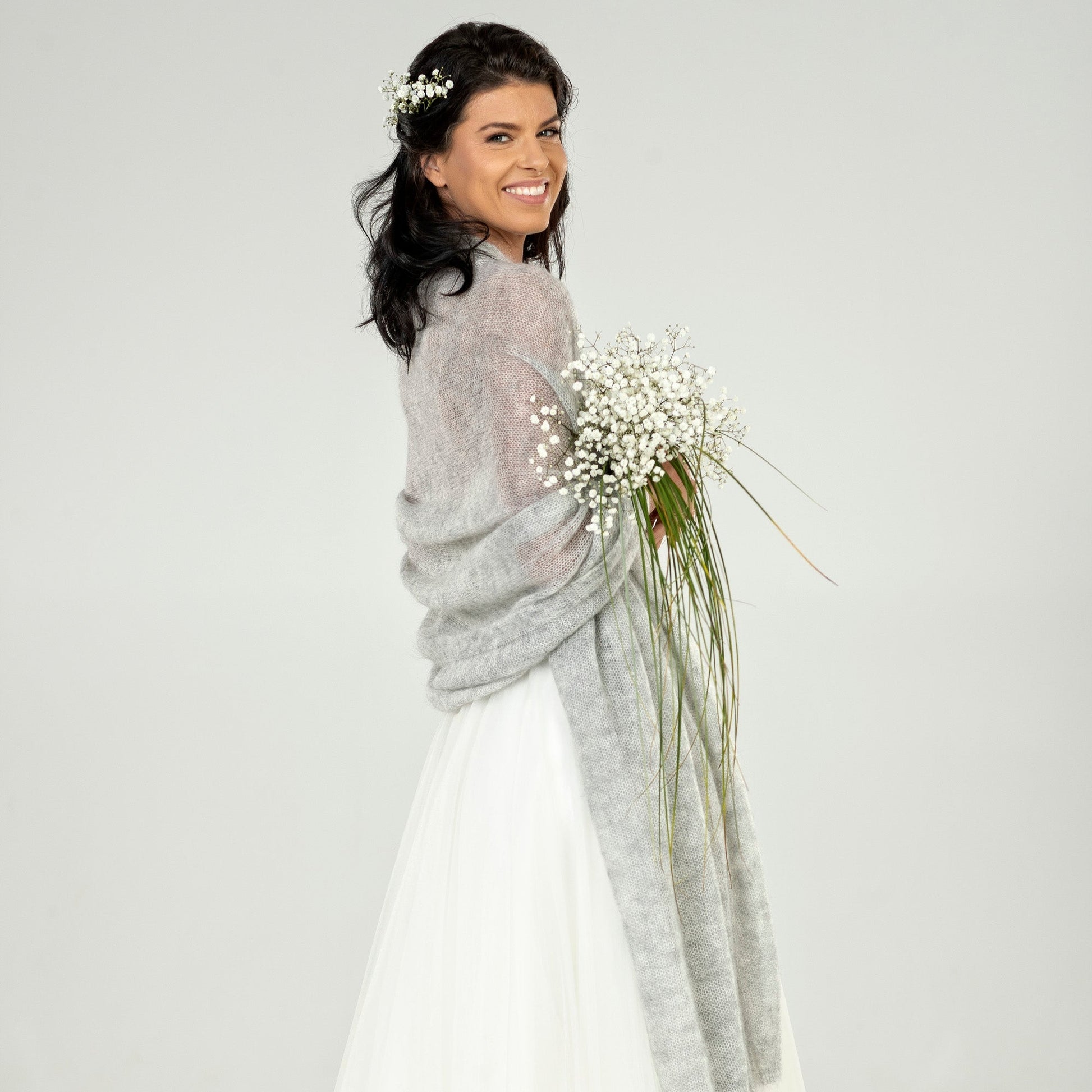 Woman in a wedding dress with a gray cape 